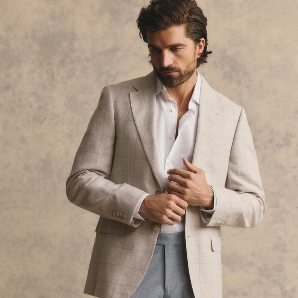 Model wearing a taupe sports coat with a soft blue check by Cambridge