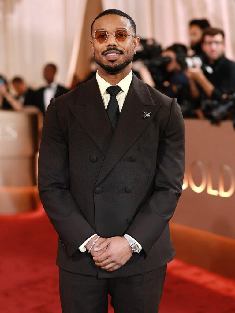 Michael B Jordan at the 2026 Golden Globes wearing a brown double breasted dinner suit with a butter yellow shirt and necktie
