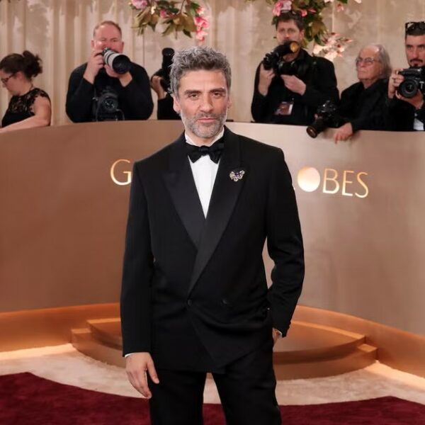 Oscar Isaac at the 2026 Golden Globes in a peak lapel double and a wing tip shirt with a butterfly bow tie