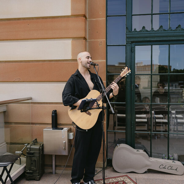 Tyler Chapman performs acoustic guitar at the wedding ceremony