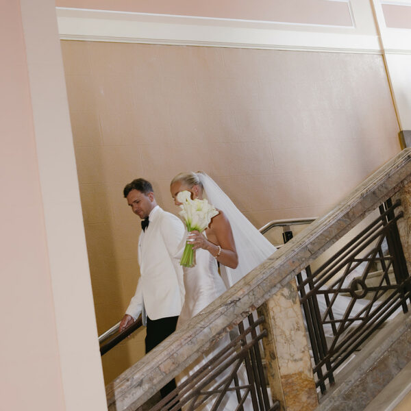The married couple walk down the stairs at Newcastle City Hall