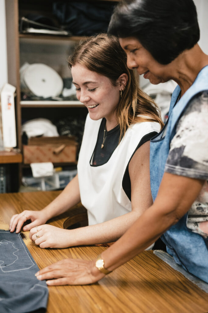 A seamstress from Rundle Tailoring instructs her trainee